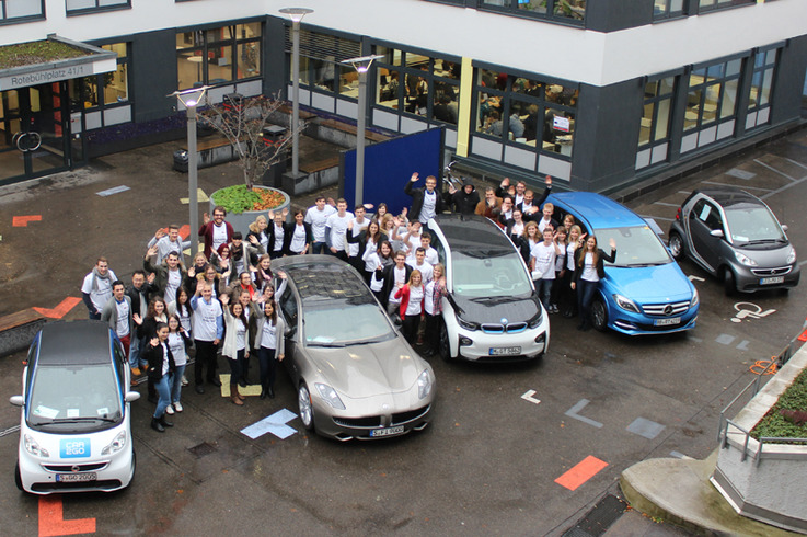 Die Studierenden zwischen den verschiedenen Elektro-Testfahrzeugen.