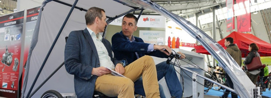 Prof. Mandel und Cem Özdemir MdB mit dem EduMotion-Fahrzeug auf der i-mobility-Messe