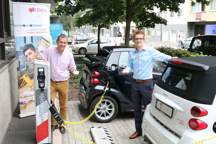 Prof. Dr. Harald Mandel und der DHBW Stuttgart-Absolvent Till Surek  präsentieren die Ladekarten für die Solarstromtankstelle der Hochschule.