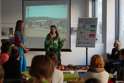 Zwei Studierende in afrikanischer traditioneller Kleidung präsentieren ihr Projekt.