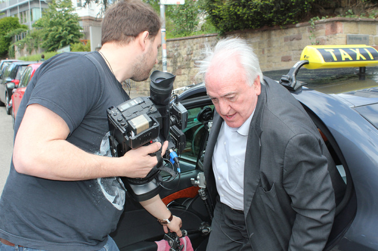 Prof. Gondring mit einem Kameramann nach der Fahrt im Video-Taxi.